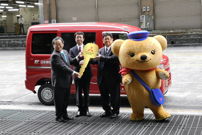 左から三菱自動車の若林陽介執行役員、日本郵便の上尾崎幸治執行役員、生島顕一銀座郵便局長、そしてマスコットの「ぽすくま」君